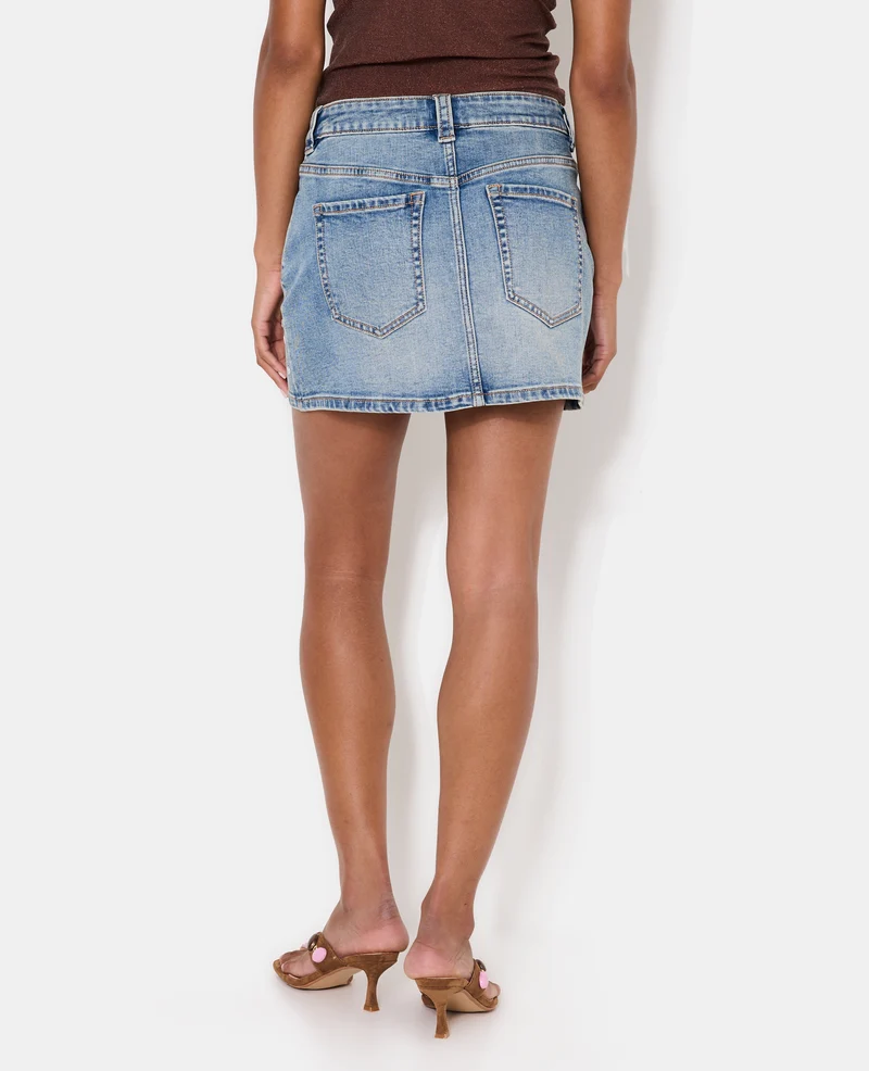 Jupe mini en jean avec œillets métalliques