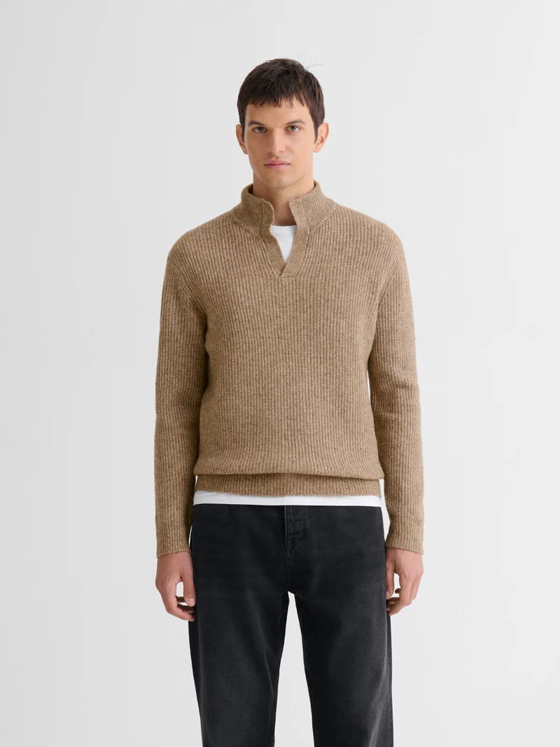 Pull col montant ouvert en maille perlée